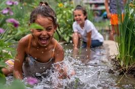 Two children splash in a flooded garden